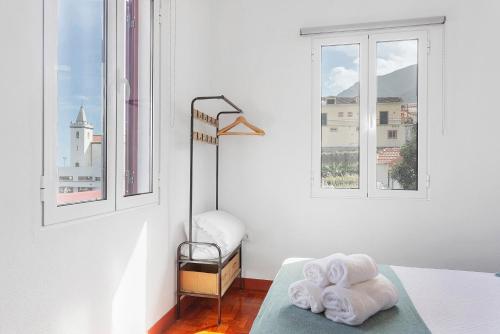 a bedroom with two towels on a bed with windows at Casa Da Avó Ferreirinha in Seixal