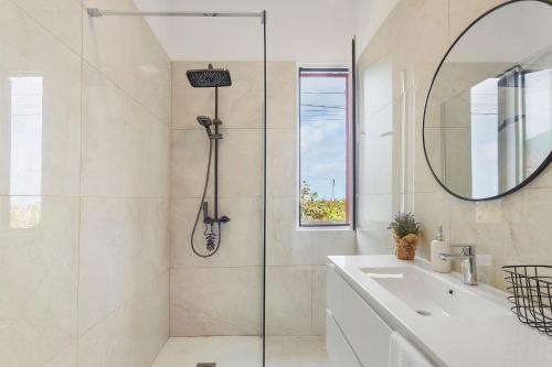 a bathroom with a shower and a sink and a mirror at Casa Da Avó Ferreirinha in Seixal