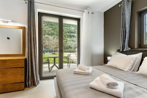 a bedroom with two beds and a balcony at Sokol stone house in Vlikhón