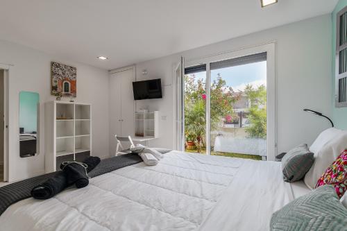 a large white bed in a room with a window at Quarto do Papagaio in Palmela