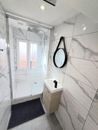 a bathroom with a shower and a sink and a mirror at La Suite Prestige in Château-Thierry