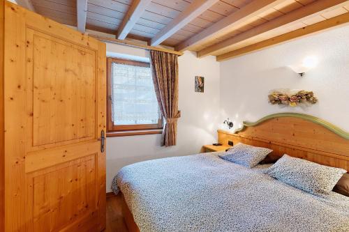 a bedroom with a wooden bed and a window at La Coccinella Livigno in Livigno