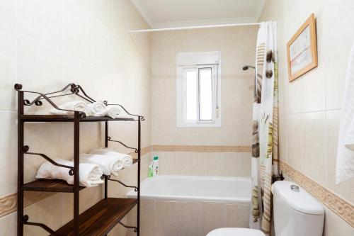 a bathroom with a tub and a toilet and a sink at Chalet Isla del Sotillo in Chiclana de la Frontera
