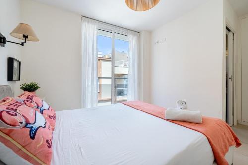 a white bedroom with a large bed and a window at Apartamento Sf2 in L'Ametlla de Mar