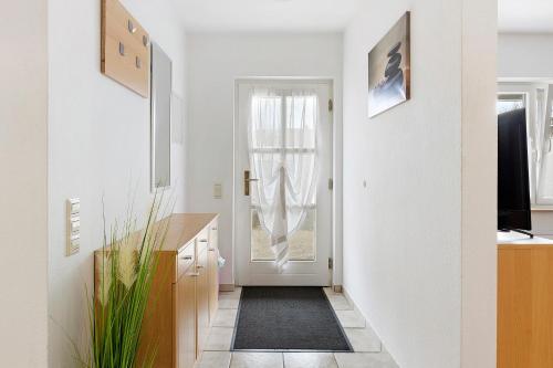 a hallway with a white door and a black rug at Ferienwohnung Geiger in Volkertshausen
