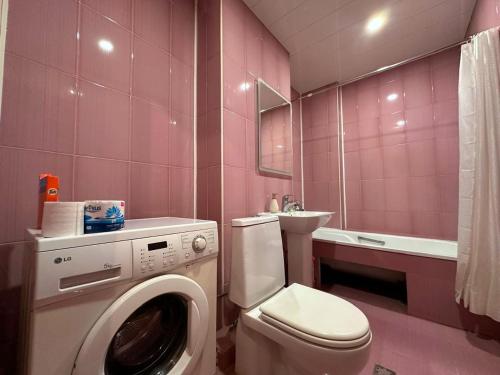 a pink bathroom with a washing machine and a sink at Republic Square FAMILY 2 bedroom 2 bathroom in Yerevan