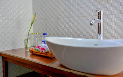 a white sink on a counter with a vase at Griya Sriwedari in Ubud