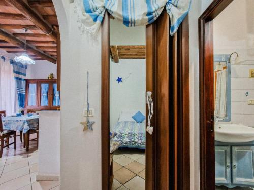 a room with a bathroom with a sink and a room with a table at Casa Veronica Rio Marina in Rio Marina
