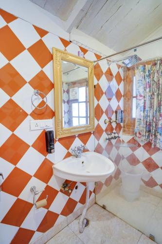 a bathroom with a sink and a mirror at Danish Villa Heritage Property in Shimla
