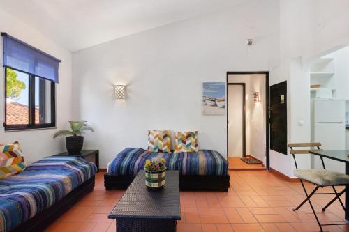 a living room with two beds and a table at T0 Pedras Del Rei in São Pedro
