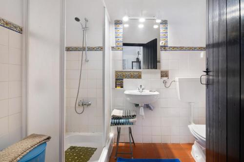a bathroom with a shower and a sink and a toilet at T0 Pedras Del Rei in São Pedro