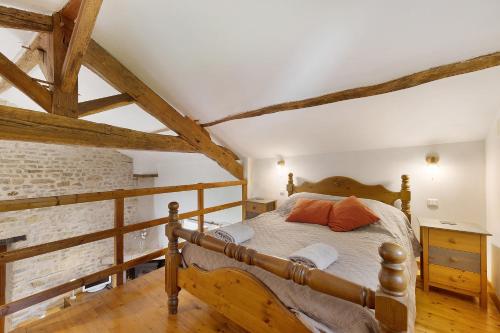 a bedroom with a wooden bed with orange pillows at Gîte des Fraignaies in Saint-Juire-Champgillon