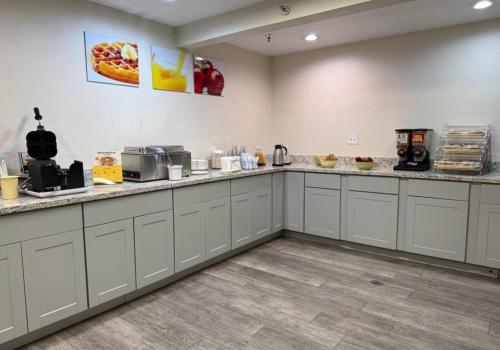 a large kitchen with white cabinets and counter tops at SureStay by Best Western Albuquerque East I-40 in Albuquerque