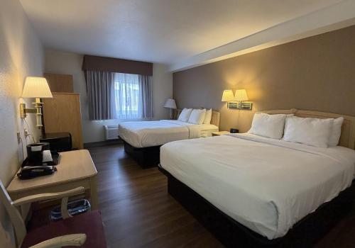 a hotel room with two beds and a desk at SureStay by Best Western Albuquerque East I-40 in Albuquerque