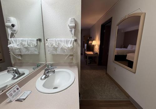 a bathroom with a sink and a mirror at SureStay by Best Western Albuquerque East I-40 in Albuquerque