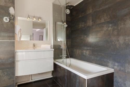 a bathroom with a sink and a tub and a mirror at Relais St Eloi, Sure Hotel Collection by Best Western in Tours