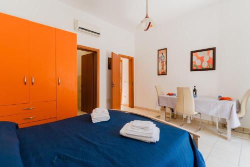 a bedroom with a blue bed and a table at La casetta 462 in Torre San Giovanni Ugento