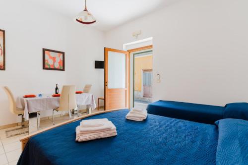 a living room with a blue couch and a table at La casetta 462 in Torre San Giovanni Ugento