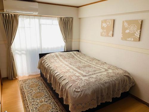 a bedroom with a bed and a window at HOTEL k&m in Tokyo