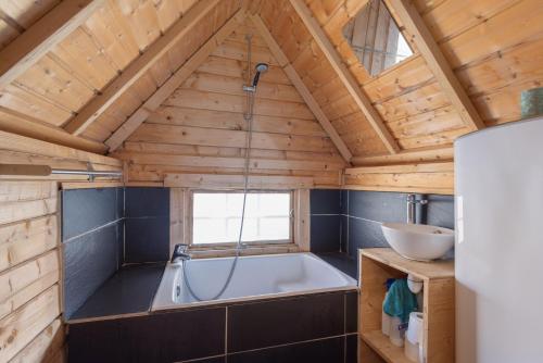 a bathroom with a tub in a wooden house at Kota Crème Catalane in Saint-André