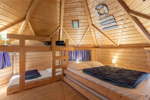 a bedroom of a log cabin with two bunk beds at Kota Crème Catalane in Saint-André
