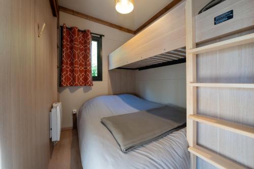 a small bedroom with a bunk bed in a trailer at Chalet 30m2 - Ouessant in Plouhinec