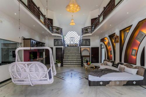 a living room with a white bed and a staircase at Aara-boutique stay udaipur in Udaipur