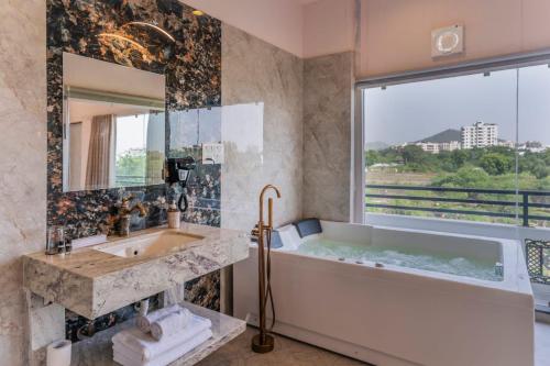 a bathroom with a tub and a sink and a mirror at Aara-boutique stay udaipur in Udaipur