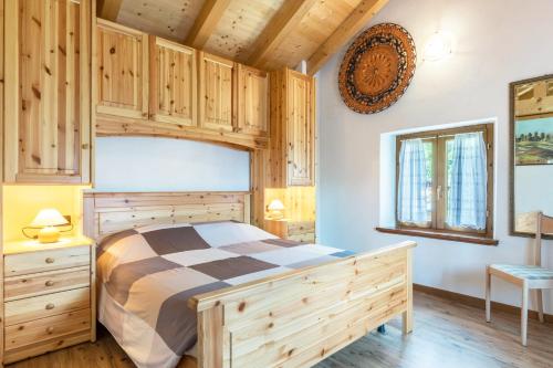 a bedroom with a bed and wooden cabinets at Baita Bocheto in Levico Terme