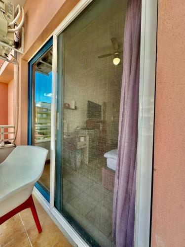 a sliding glass window in a room with a bathroom at Petit City in Orestiada