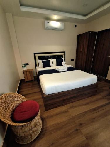 a bedroom with a large bed and a chair at D9 Restaurant and Hotel in Khetri