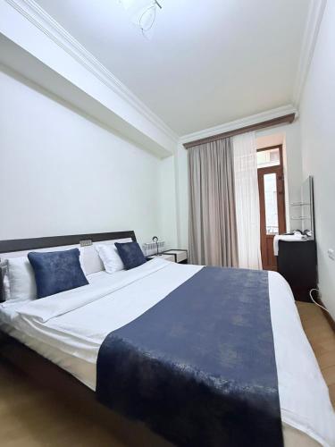 a bedroom with a large bed with blue pillows at Republic Square FAMILY 2 bedroom 2 bathroom in Yerevan