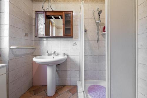 a white bathroom with a sink and a shower at Su Suergiu in San Giovanni Suergiu