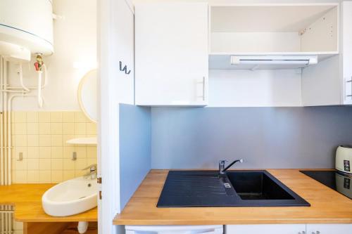 a kitchen with white cabinets and a sink at Les Mimosas - Appartement 09 in Cazaubon