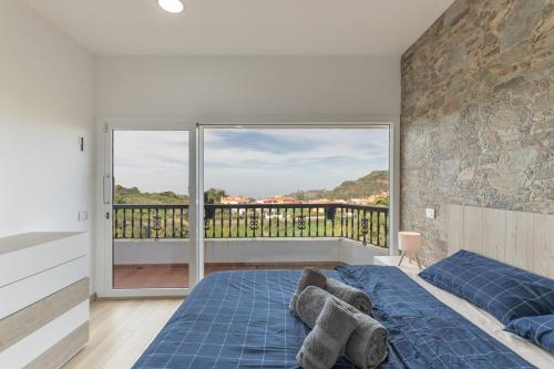 a bedroom with a blue bed and a balcony at Teror Hills in Teror