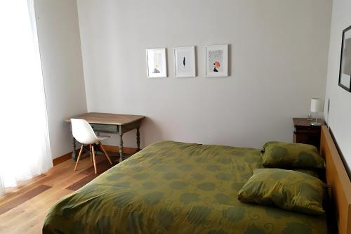 a bedroom with a bed and a desk and a chair at Les Hauts De Font Moure in Saint-Georges-des-Agoûts