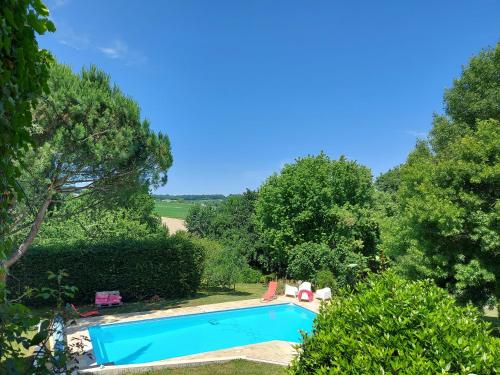 a swimming pool in a yard with trees at Les Hauts De Font Moure in Saint-Georges-des-Agoûts