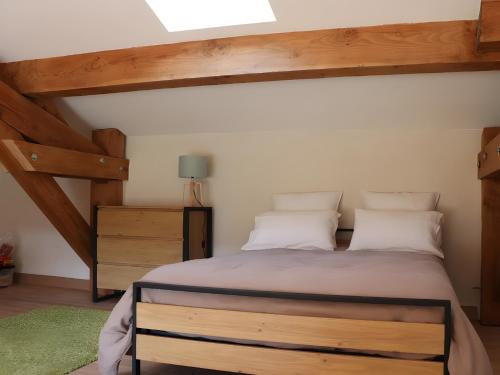 a bedroom with a large bed with wooden beams at Le Gîte du Petit Verdot in Béziers