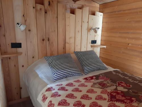 a bedroom with a bed with two pillows at Gîte à la ferme- Chalet à la nuitée in Mazan-lʼAbbaye