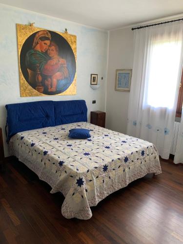 a bed in a bedroom with a painting on the wall at Casa di Eli e Matte in Le Serucce