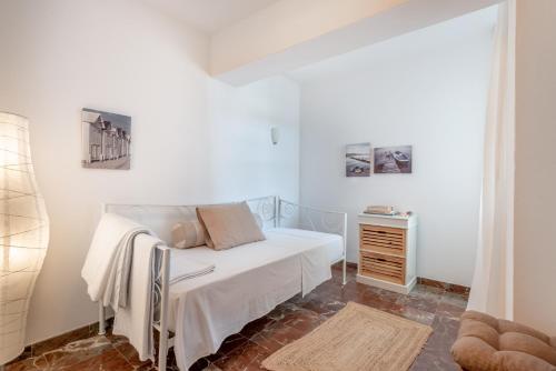 a white bedroom with a bed and a dresser at Bennassar 3 in Felanitx