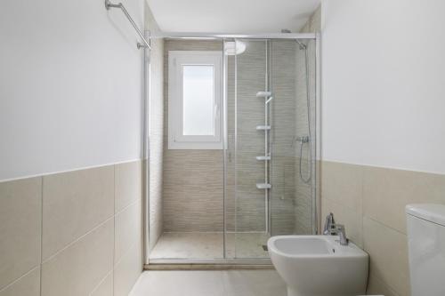 a bathroom with a shower with a toilet and a sink at Moderno Apartamento Atlanterra in Zahara de los Atunes