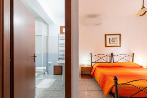 a bedroom with a bed and a bathroom with a toilet at Hotel Da Concetta a Jerzu in Jerzu