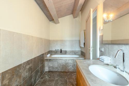 a bathroom with a sink and a tub at Villa Aquila in Trequanda