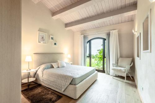 a bedroom with a bed and a window and a chair at Villa Aquila in Trequanda