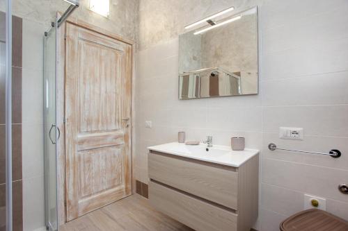 a bathroom with a sink and a shower and a mirror at Oasi del relax in Budoni