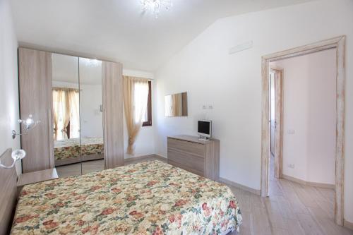 a bedroom with a large bed and a mirror at Oasi del relax in Budoni