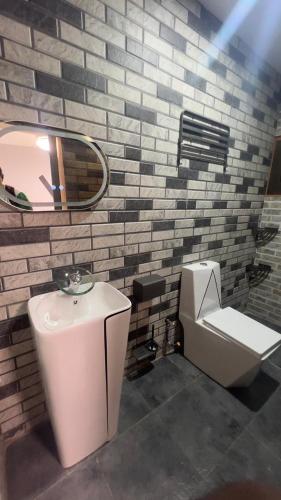 ein Badezimmer mit Waschbecken, Toilette und Spiegel in der Unterkunft Résidence AELA in Banfora