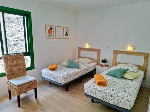 a room with two beds and a chair in it at Canaima 223 - Puerto Rico in Puerto Rico de Gran Canaria