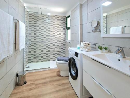 a bathroom with a toilet and a sink and a washing machine at Canaima 223 - Puerto Rico in Puerto Rico de Gran Canaria
